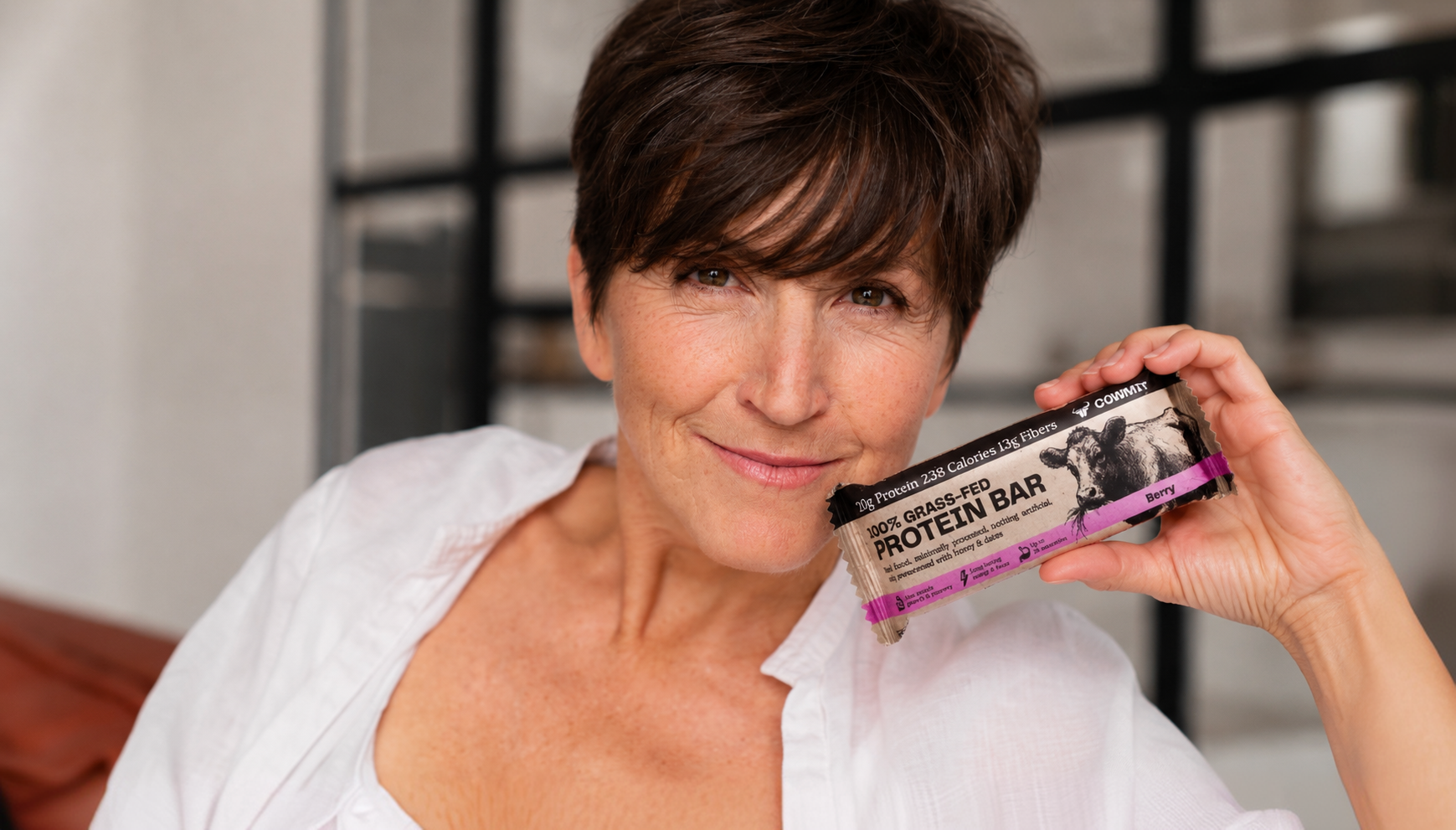 Woman holding a Cowmit Berry protein bar
