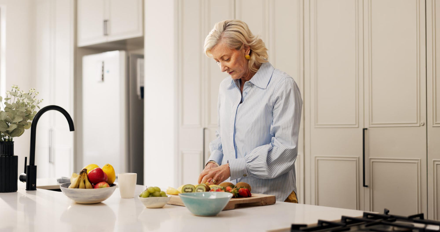 Woman preparing fruit in a bright kitchen